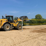 Beachvolleyball am Natursee: Mit schwerem Gerät wird der feine Spezialsand verteilt. Foto: VfL